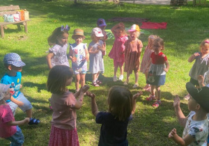 Dzieci tańczą w kole w ogrodzie przedszkolnym
